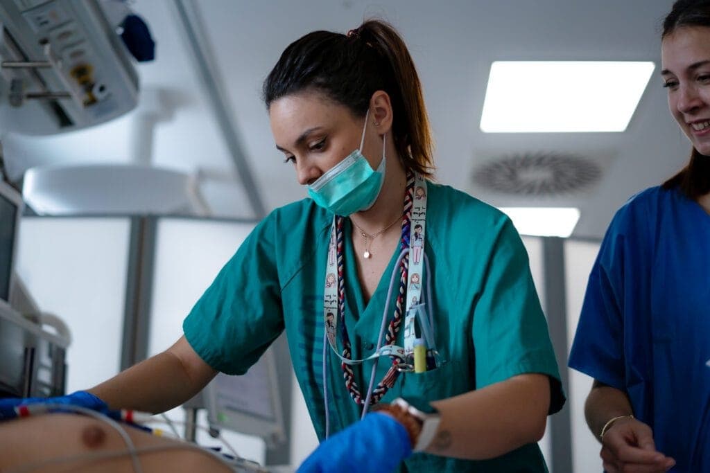 Two healthcare professionals delivering clinical treatment to a patient