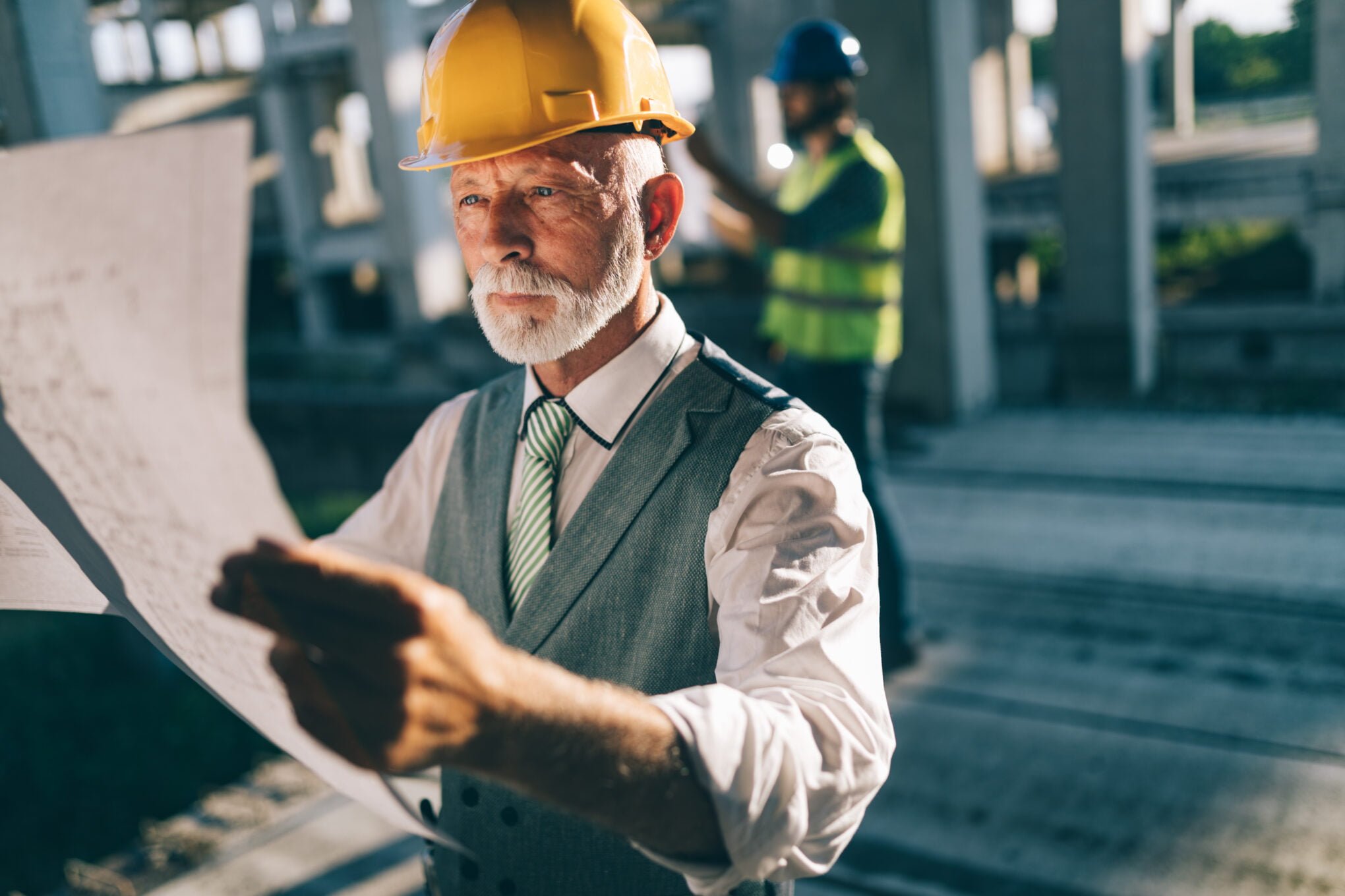Confident construction engineer, architect, businessman in hardhat on building site