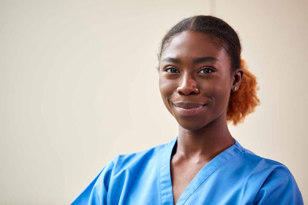Portrait Of Smiling Female Nurse Or Doctor Wearing Scrubs Portrait Of Smiling Female Nurse Or Doctor Wearing Scrubs