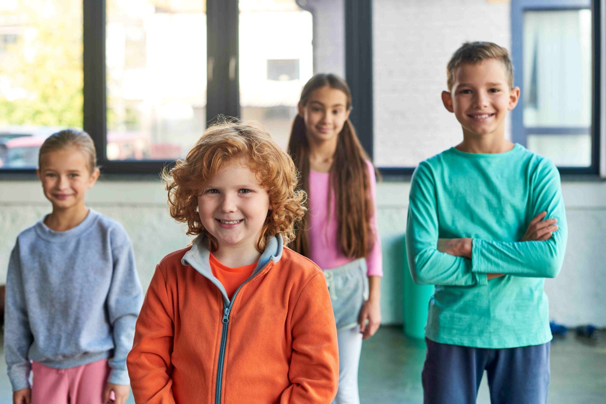 four-cheerful-preadolescent-children-posing-in-gym-2024-11-09-02-23-05-utc