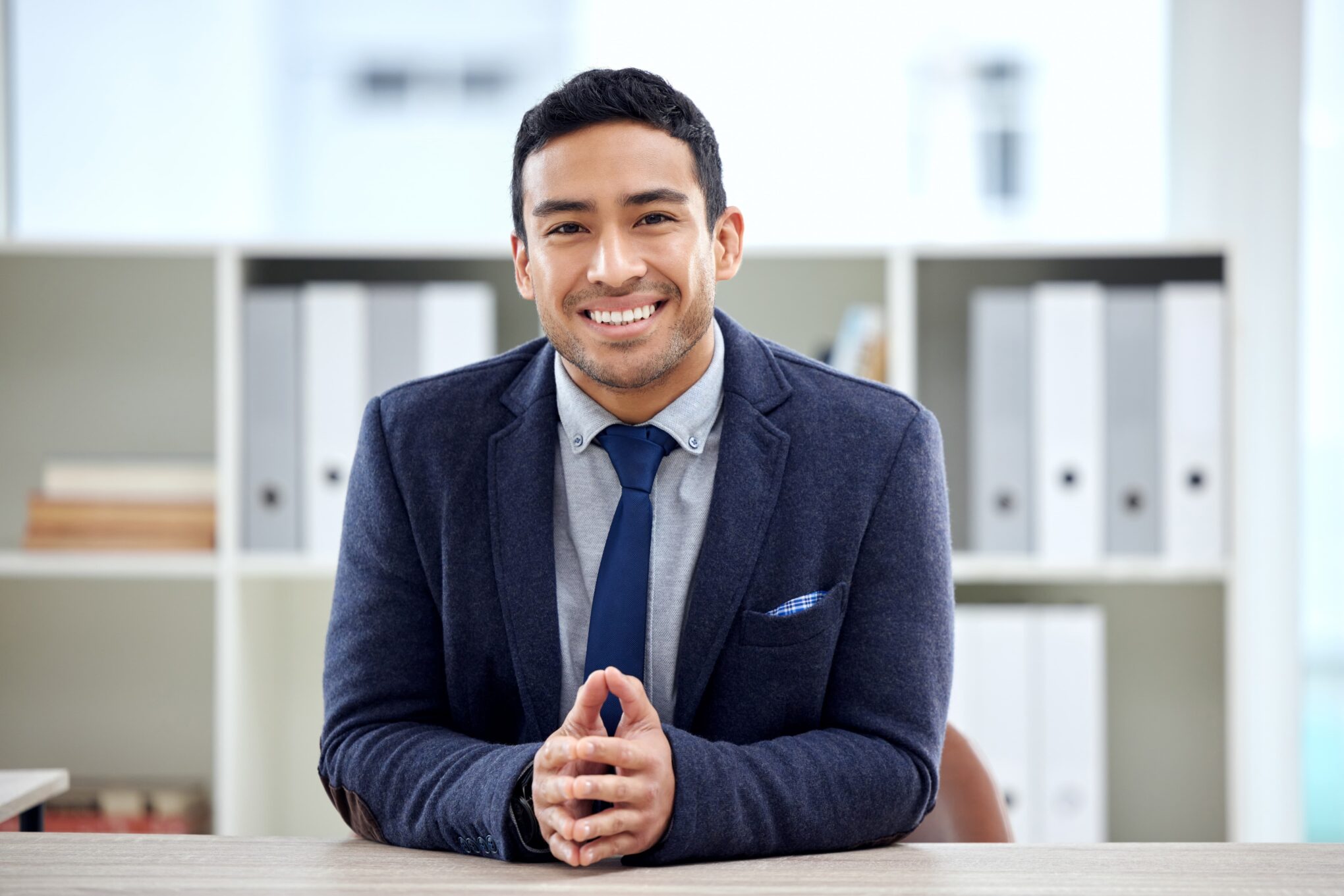 smiling-man-in-business-suit-sitting-at-desk-2026-01-09-11-06-41-utc (1)